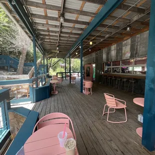 a wooden deck with tables and chairs