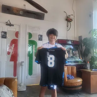 He got his team jersey with his number printed. He is so happy.