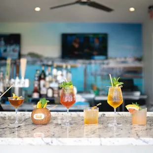 a variety of cocktails on a bar