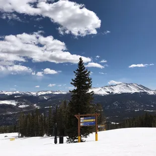 a ski slope with a sign in the foreground
