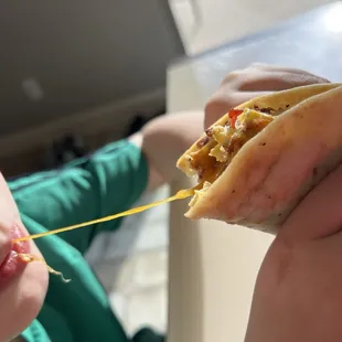 My kiddo enjoying the cheesy goodness of his bacon egg breakfast taco!