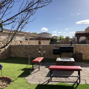 a patio with a table and benches