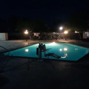 Pool at night. Handicapped chair in the for ground.