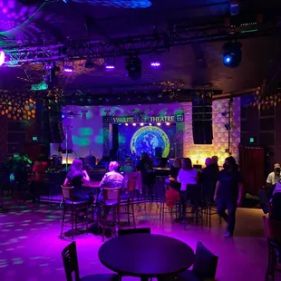 people sitting at tables in a dark room
