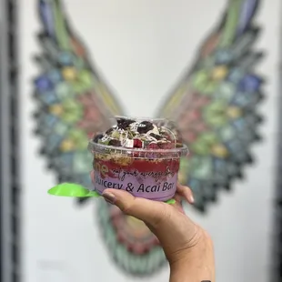 a hand holding a cup of ice cream