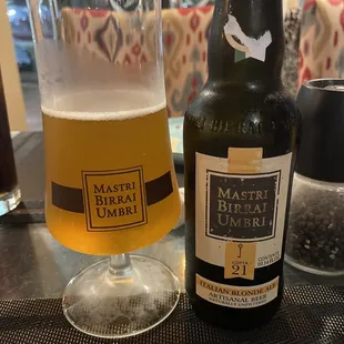 a glass of beer and a bottle on a table