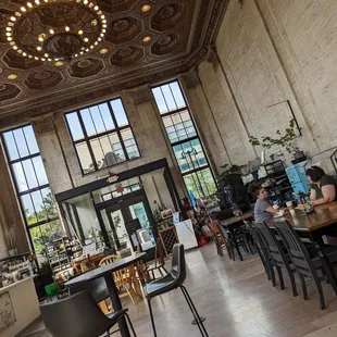 a dining area with a chandelier and tables