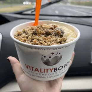 a hand holding a cup of ice cream