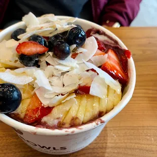 a bowl of fruit topped with coconut flakes