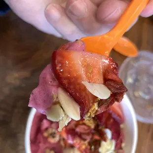 a hand holding a spoon full of food