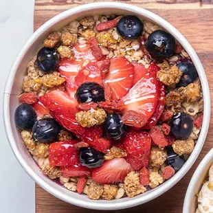 a bowl of oatmeal with strawberries and blueberries