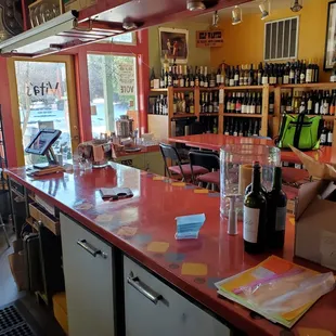 a red counter top with bottles of wine on it