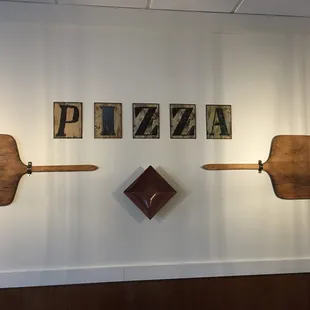 a wall with a pizza sign and a clock