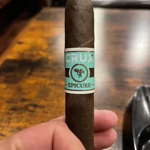 a hand holding a cigar