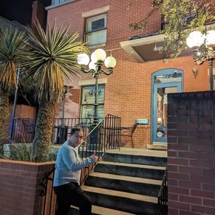 a woman sitting on the steps of a house