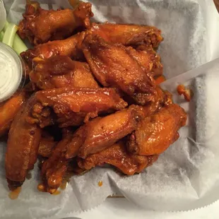 a basket of chicken wings with dipping sauce