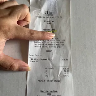 a person's hand holding a receipt