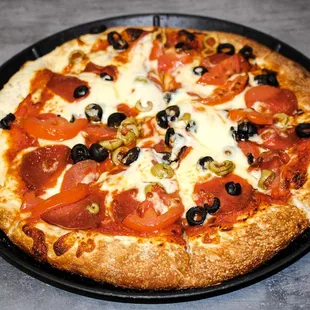 Pizza with tomatoes and black and green olives