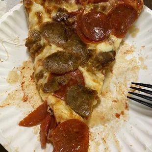 Slice of pepperoni and Italian sausage round pizza