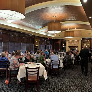 a large group of people sitting at tables in a restaurant