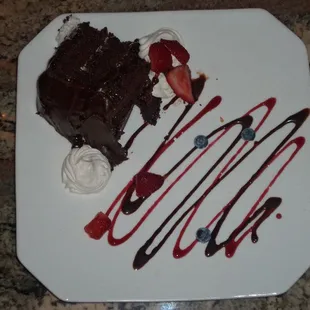 a piece of chocolate cake with whipped cream and strawberries