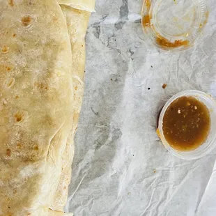 a burrito with a side of sauce