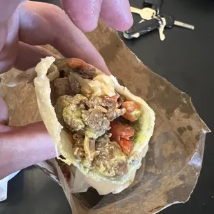 a hand holding a burrito