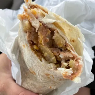 a hand holding a burrito