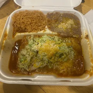 Beef enchiladas with red sauce rice and beans.