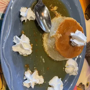 a plate of food with whipped cream and a spoon