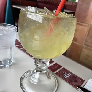 a margarita in a glass with a red straw