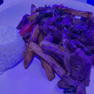 a plate of food with rice and steak