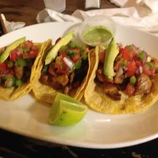 three tacos on a white plate