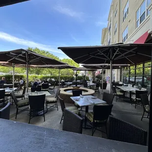 an outdoor dining area with tables and umbrellas