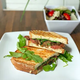 Merguez Panini:
Moroccan Beef Sausage, Sauteed mushrooms, Mozzarella, Sauteed onions, Arugula, Mushroom pesto aioli.