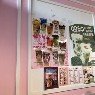 a pink wall with posters on it