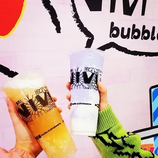 a hand holding two drinks