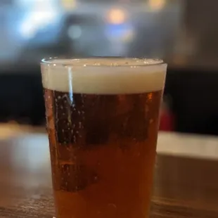 a glass of beer on a napkin