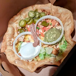 a pizza in a box with toppings