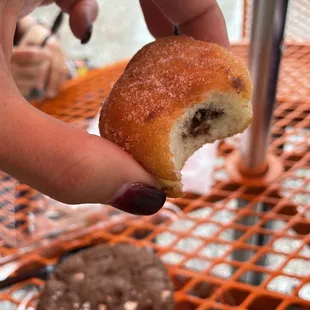 a hand holding a half eaten doughnut