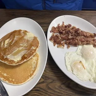 Corned beef hash with two eggs and pancakes on the side
