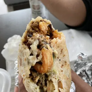 a hand holding a burrito