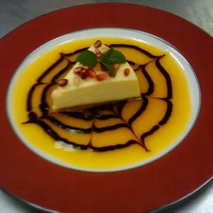 Vanilla Cheesecake, Mango Coulis, Chocolate Drizzle.