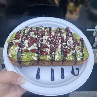 a piece of avocado toast on a paper plate