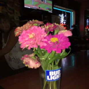 a vase of flowers in front of a television