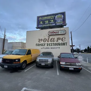 cars parked in a parking lot in front of a restaurant