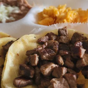 (2) Carne Asada tacos with beans and rice.