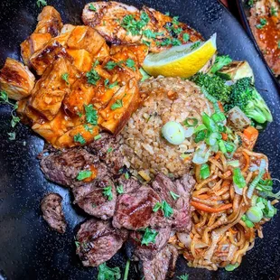 Plate combo with filet mignon, spicy garlic chicken, and salmon.