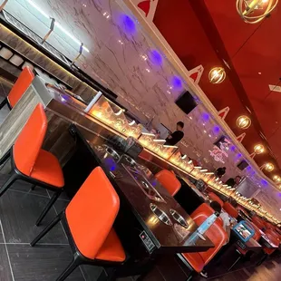 a long bar with orange chairs