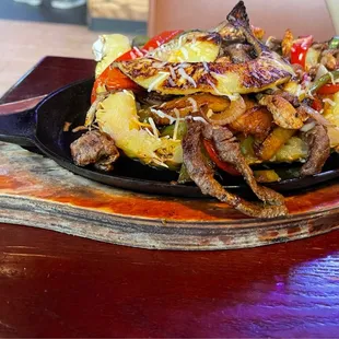 These are the specialty Pineapple Fajitas. Beef &amp; chicken plus onions, peppers, &amp; a tasty sauce on top of a whole pineapple portion.